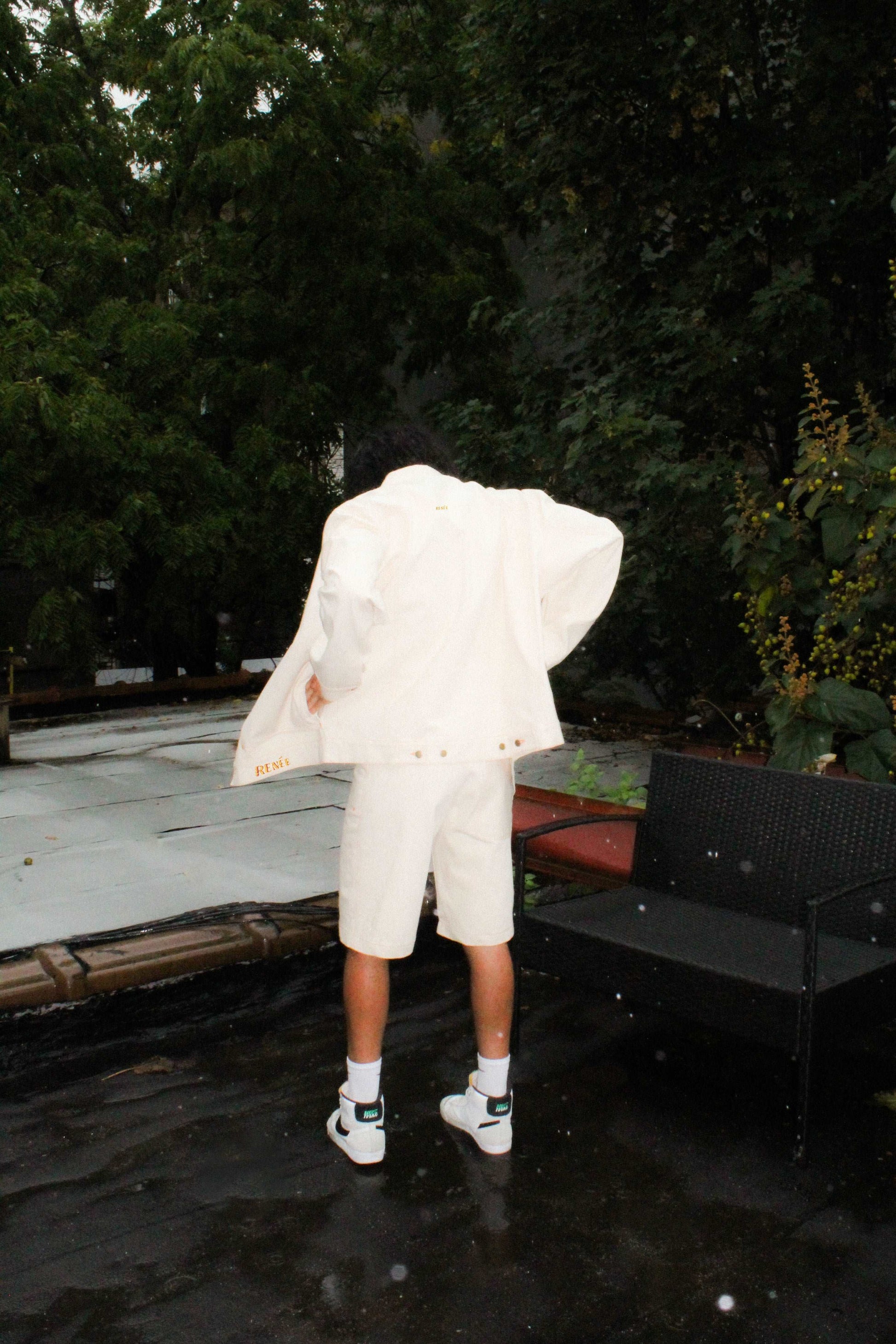 male model wearing oversized denim jacket with logo embroideries and matched denim shorts