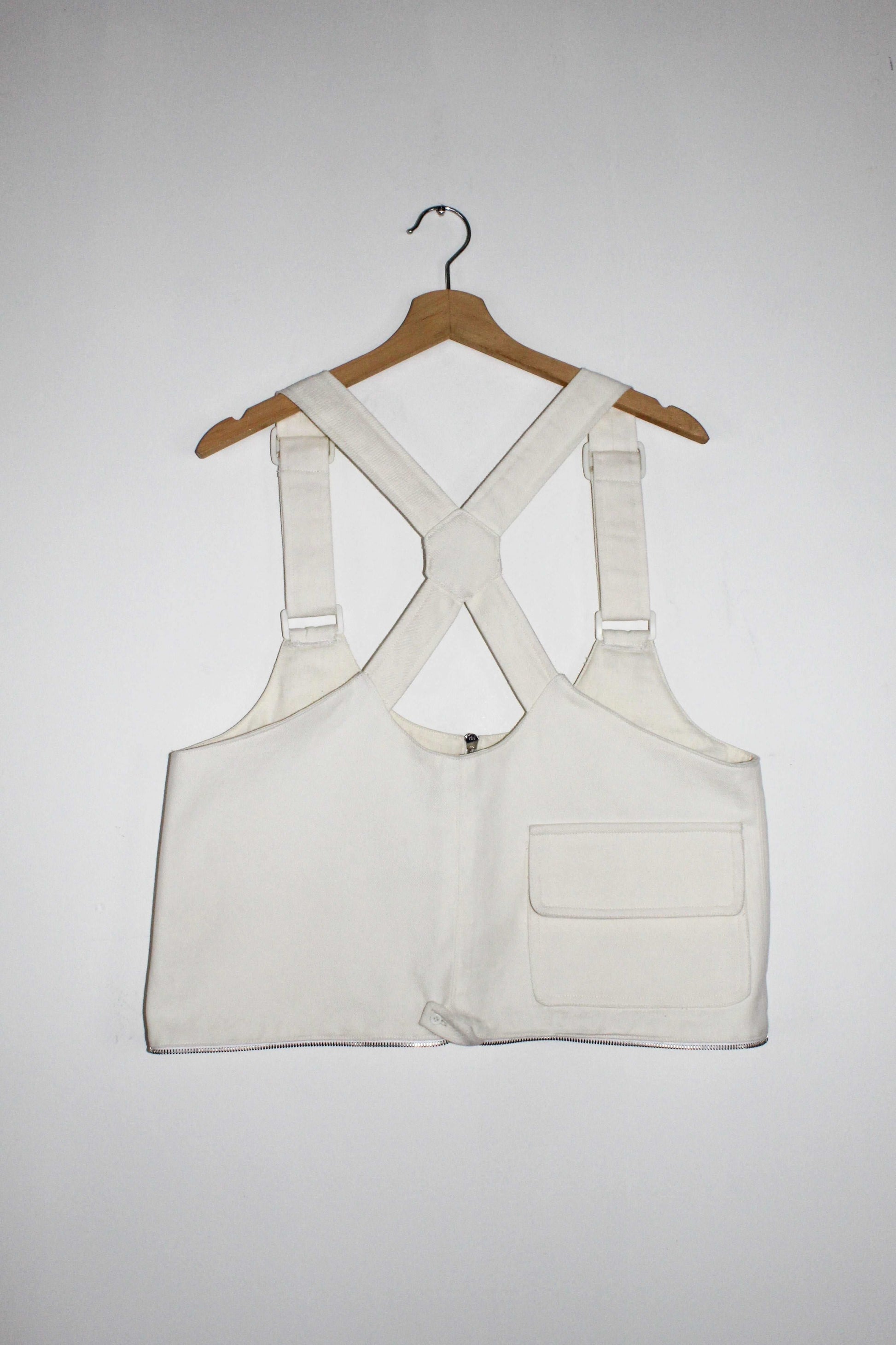 Back view White denim cropped adjustable strap convertible vest bag with cargo pockets