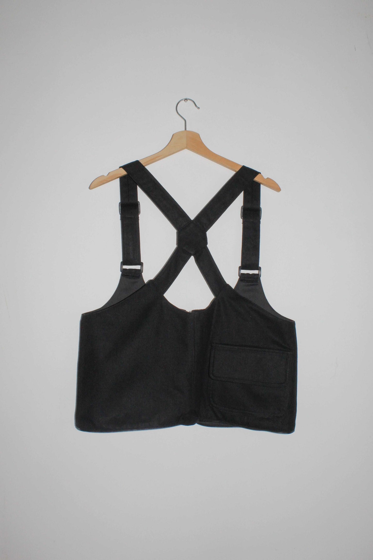 Back view black denim cropped adjustable strap convertible vest bag with cargo pockets