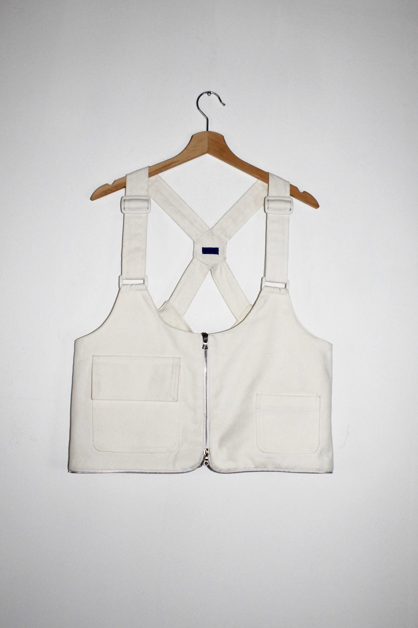 Front view White denim cropped adjustable strap convertible vest bag with cargo pockets