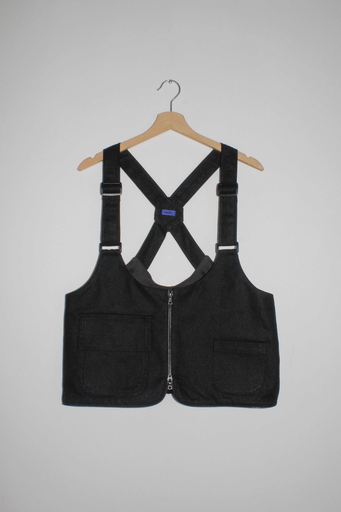 Front view black denim cropped adjustable strap convertible vest bag with cargo pockets