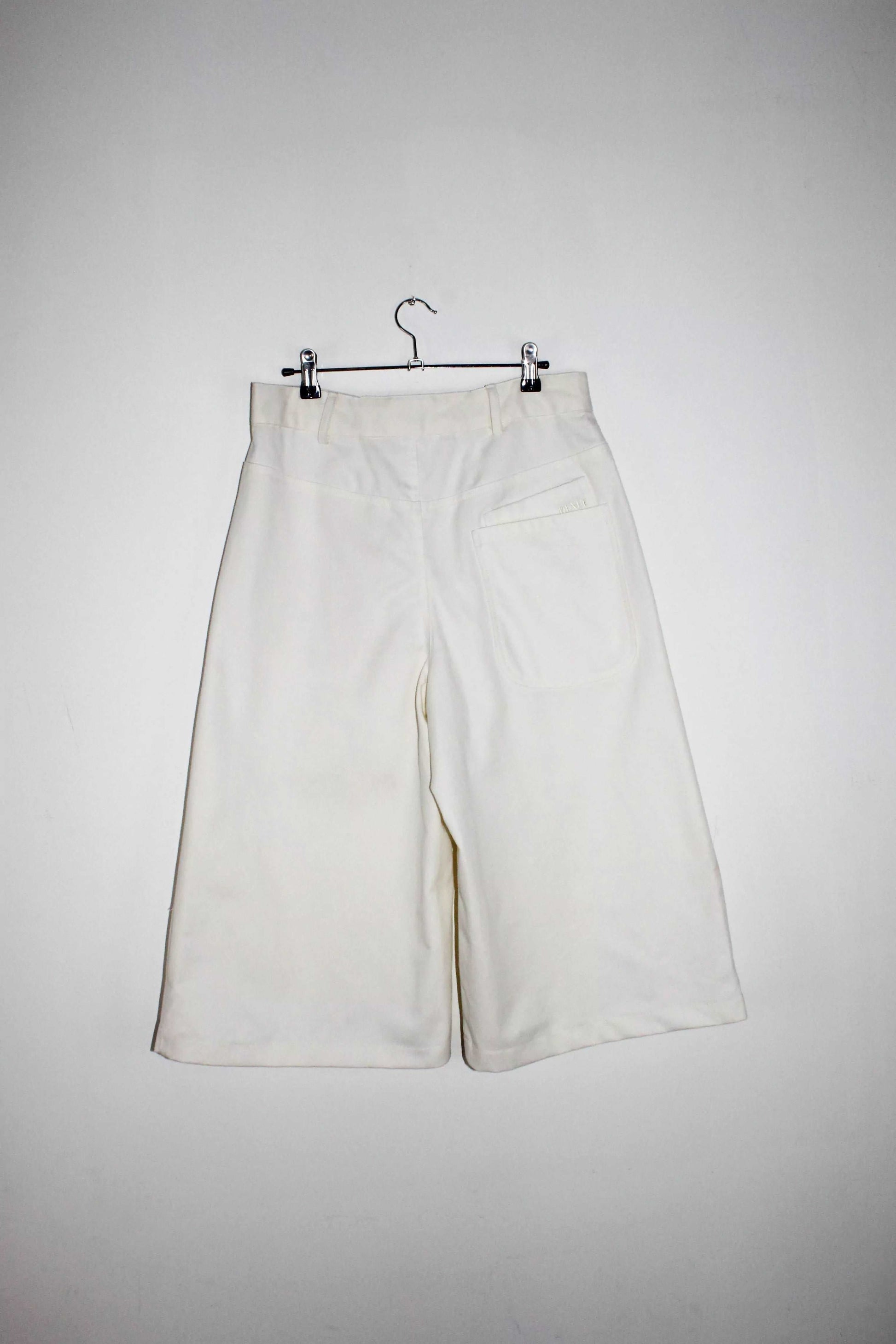Back view lightweight long white denim shorts with removable screw buttons. Has fitted waist and 90s vintage details