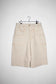Front view cream shorts inspired by 90's vintage details. Featuring removable denim button, double pocket and Logo embroidery.
